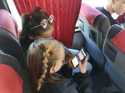 dzieci w autobusie grające na smartfonie
