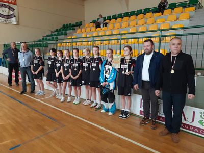 Drużyna dziewcząt w czarnych strojach na boisku 