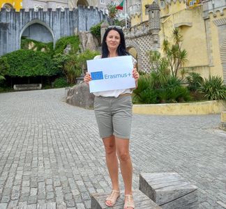Uczestniczka trzymająca grafikę Erasmus+ na placu przed Pałacem w Lizbonie.