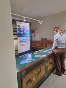 kobieta przy stole z ulotkami promocyjnymi