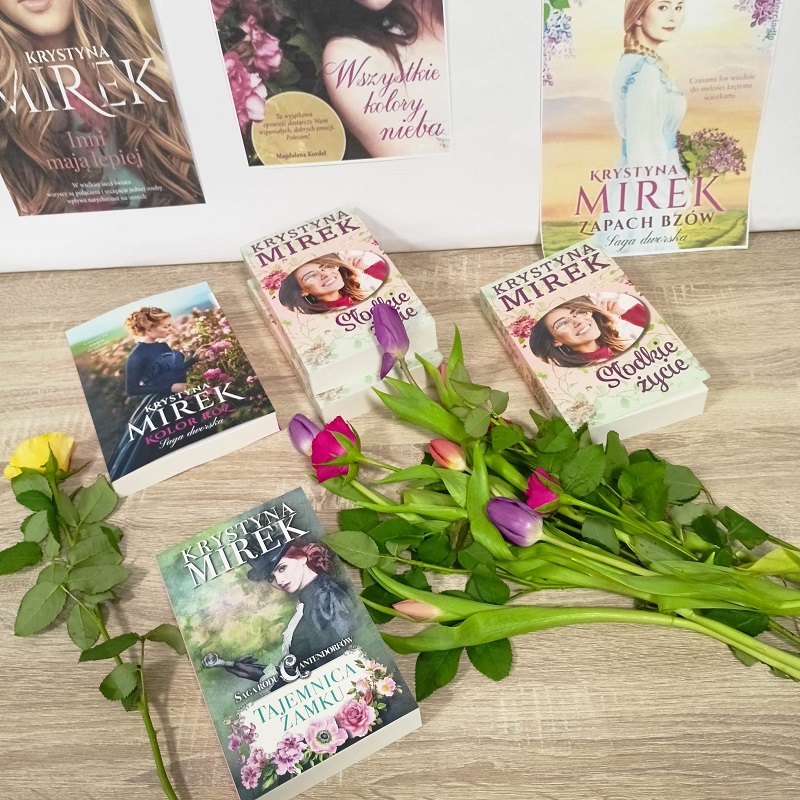 Książki pisarki Krystyny Mirek z położonym bukietem kwiatów